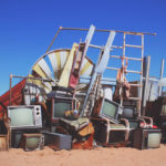 Local Junk Removal services remove a pile of old TVs carefully left in the sand, providing efficient Bulk Hauling solutions.