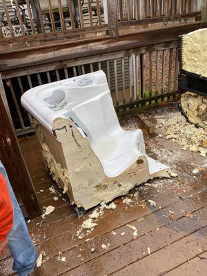 A man is standing next to a broken bathtub on a deck in pictures of our services.