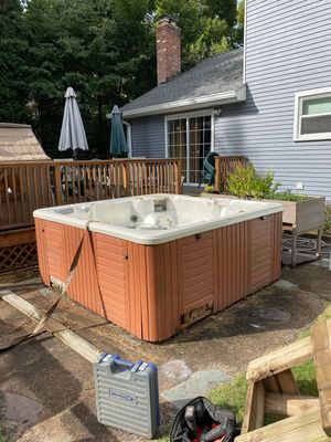 A hot tub in the backyard of a house showcasing our services through pictures.