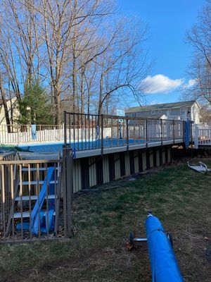 A backyard with a pool and a ladder.