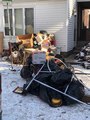 A pile of garbage in front of a house.